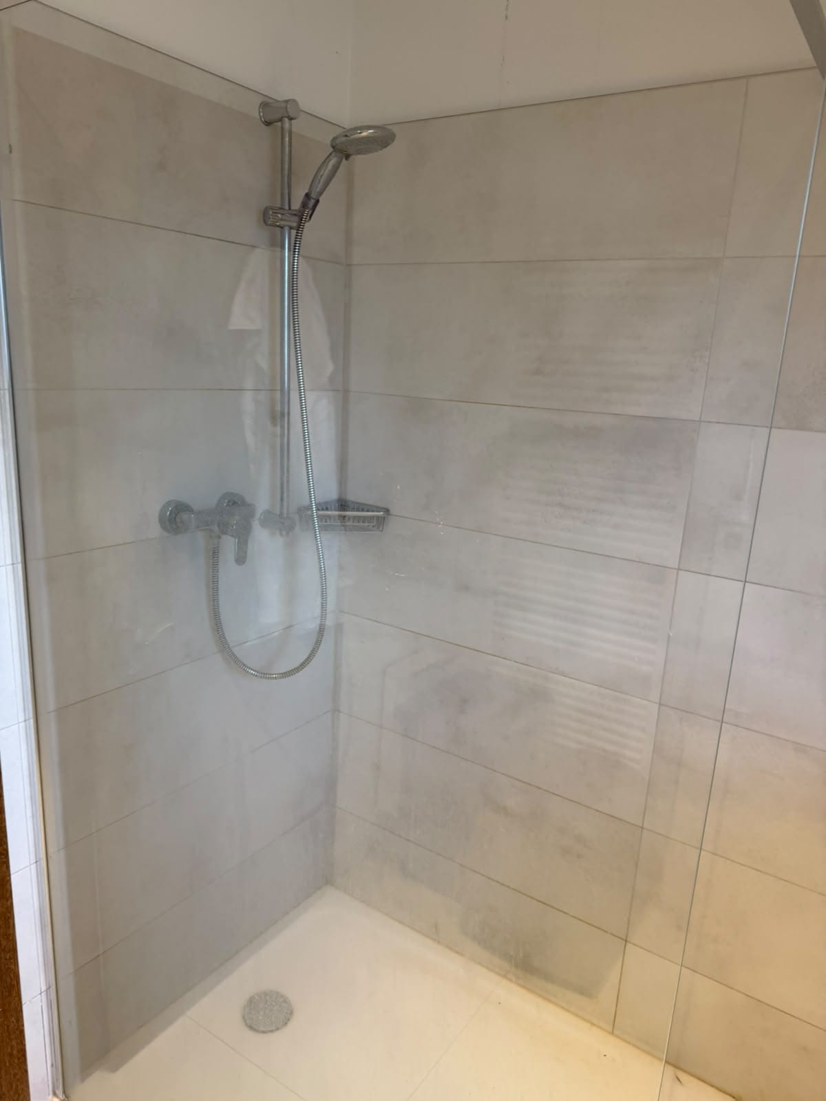 Vorher: Dusche mit Kalk- und Wasserflecken auf Glas und Fliesen