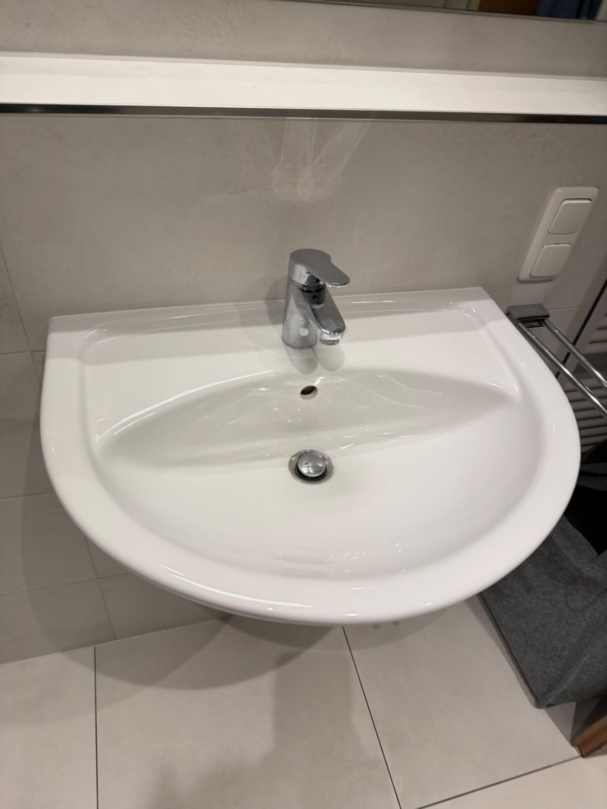 Sauberes weißes Waschbecken mit glänzender Armatur
